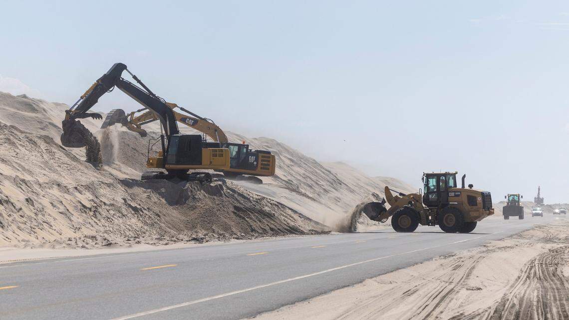 NCDOT crews clear sand along N.C. 12&nbsp;in the Pea Island National Wildlife Refuge on Sept. 14, 2023, as Hurricane Lee churns hundreds of miles offshore in the Atlantic Ocean.