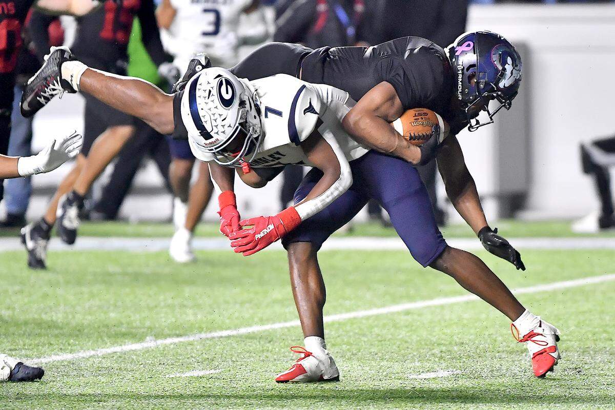 Rolesville running back Amir Brown (2) dives over Grimsley free safety Ryan Debow (7) during the second half. The Rolesville Rams and the Greensboro Grimsley Whirlies met in the NCHSAA 4A football Championship Game in Chapel Hill, N.C. on December 20, 2024.