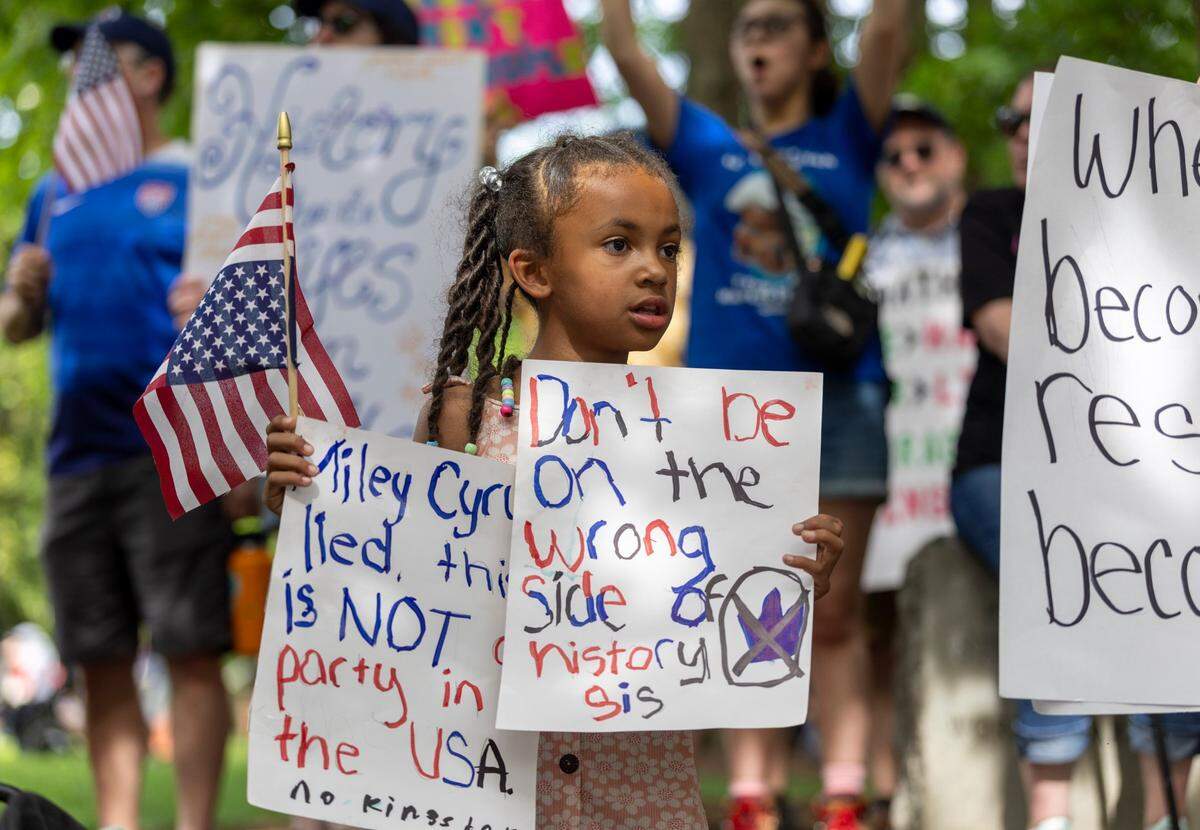 Addilyn Wunderlich of Henderson, N.C. holds her signs during the ‘No Kings’ rally at the North Carolina State Capital on Saturday, June 14, 2025 in Raleigh, N.C.