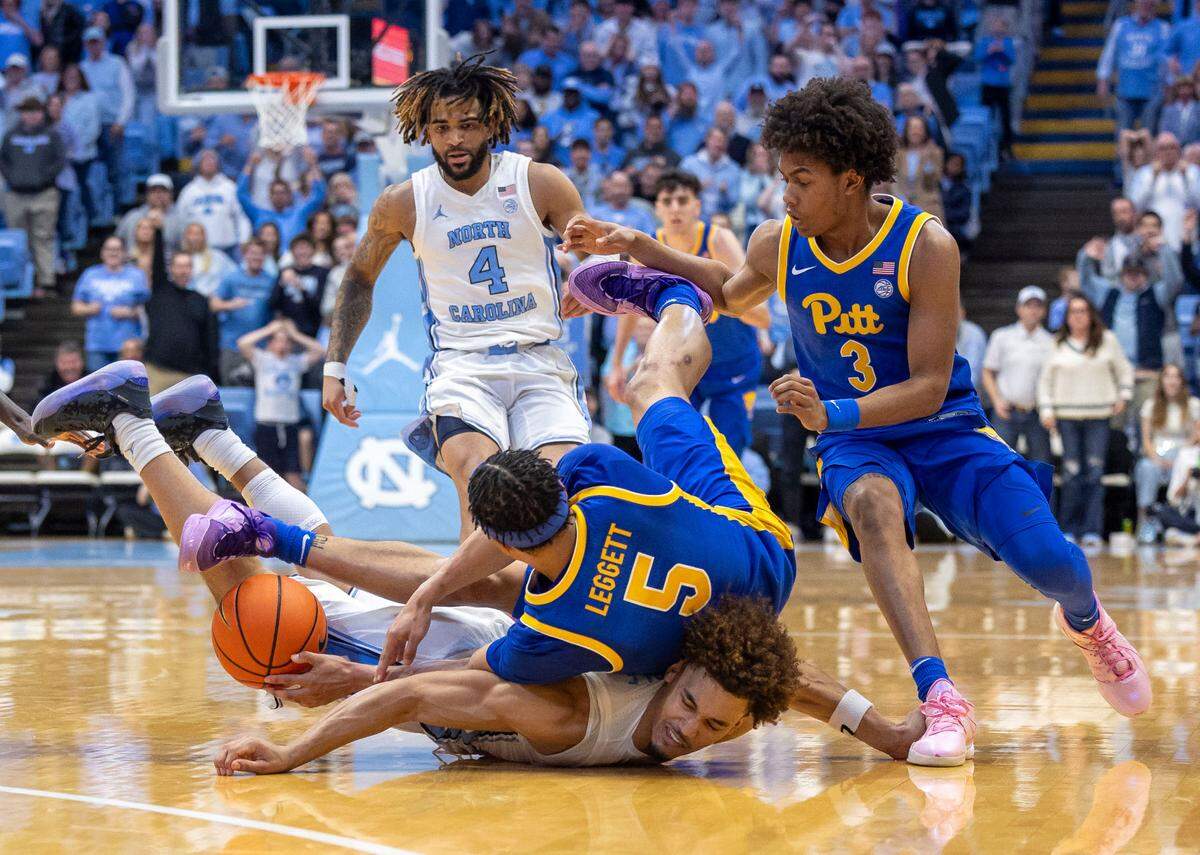 Pitt guard Ishmael Leggett (5) dives over North Carolina guard Seth Trimble (7) in a desperate scramble for a loose ball with less than ten seconds to play on Saturday, February 8, 2025 at the Smith Center in Chapel Hill, N.C. The Tar Heels held on to a one point lead to defeat Pitt 67-66.
