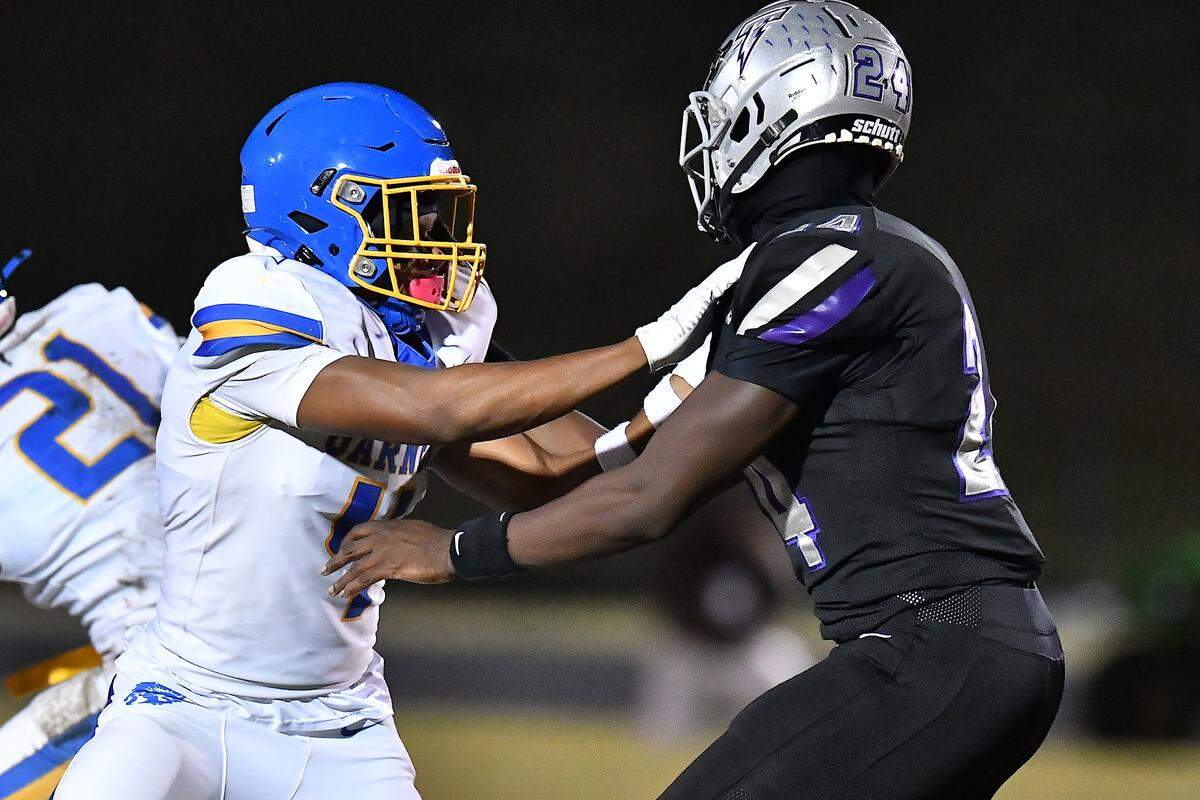 South Garner defensive end Ebenezer Ewetade (24) battles Garner running back Amir Wallace (4) during the first half. The South Garner Titans and the Garner Trojans met in a conference football game in Raleigh, N.C. October 17, 2025