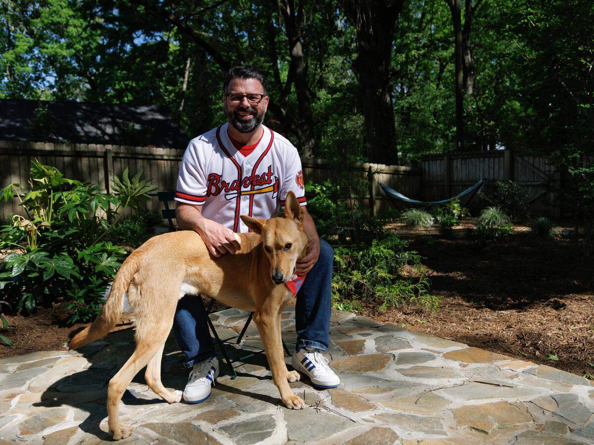 Chris Buccafusco poses for a photograph with his dog, Phil, a two-year-old Shepherd rescue mix, on Wednesday, April 16, 2025, in Durham, N.C. Buccafusco and his brother want to change the Atlanta Braves name to “Bravest” to respect Native Americans.