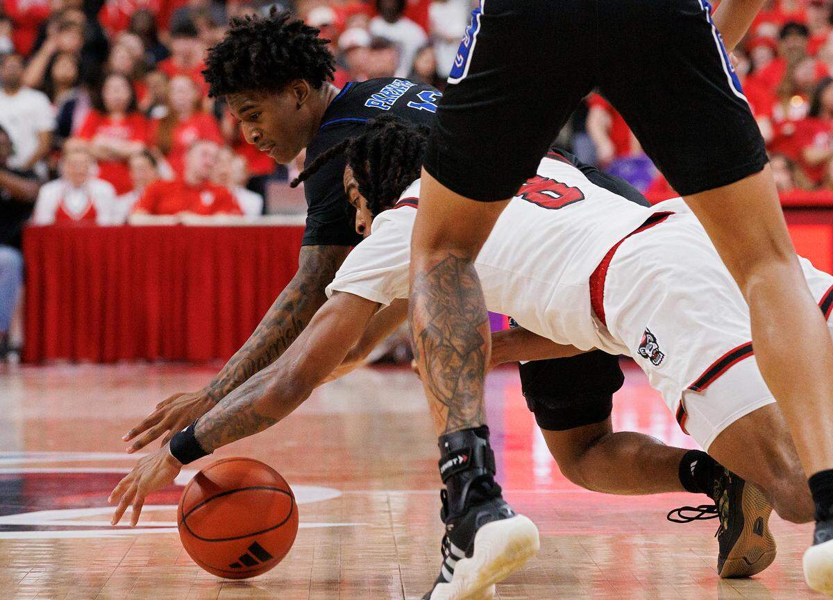 N.C. State’s Jayden Taylor and Presbyterian’s Carl Parrish dive after a loose ball during the second half of the Wolfpack’s 81-72 win on Friday, Nov. 8, 2024, at Lenovo Center in Raleigh, N.C.