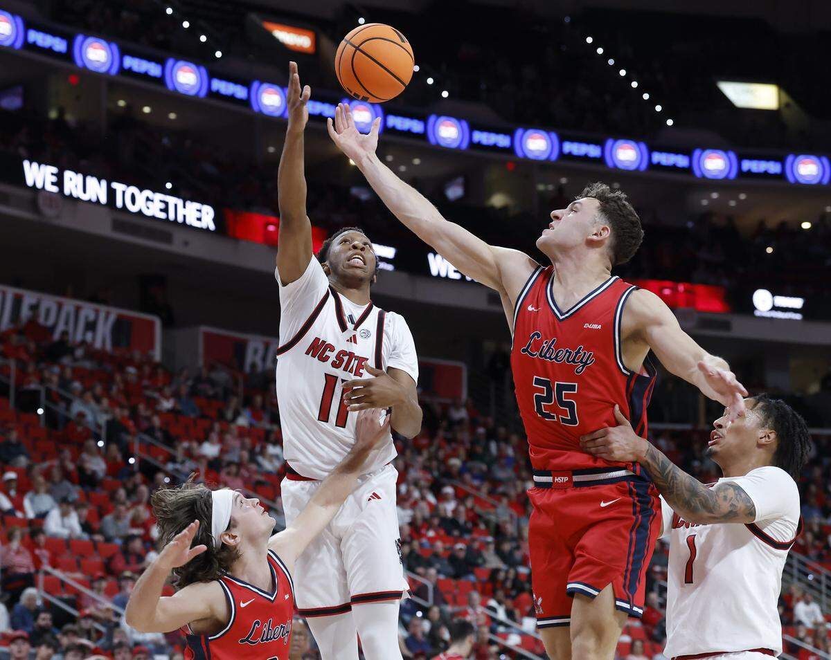 N.C. State’s Quadir Copeland battles for a rebound with Liberty’s Zach Cleveland during the first half of the Wolfpack’s game on Wednesday, Dec. 10, 2025, at Lenovo Center in Raleigh, N.C. 