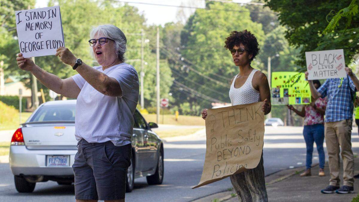 Pullen Baptist Church senior pastor Nancy Petty, left, and associate pastor Chalice Overy, center, peacefully rally with demonstrators along Creedmoor Road in Raleigh Tuesday, May 25, 2021 to memorialize the one year anniversary of George Floydís death. The rally was organized by several local churches and houses of worship.