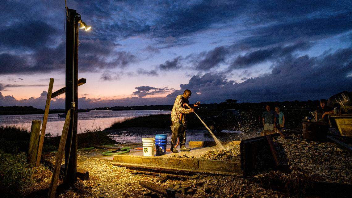 Richard Singleton an oystermen working for Bowens Island Restaurant talks to customers while cleaning oysters on the banks of the Folly River. The restaurant is holding the first oyster roasts of the season. October 10, 2021.