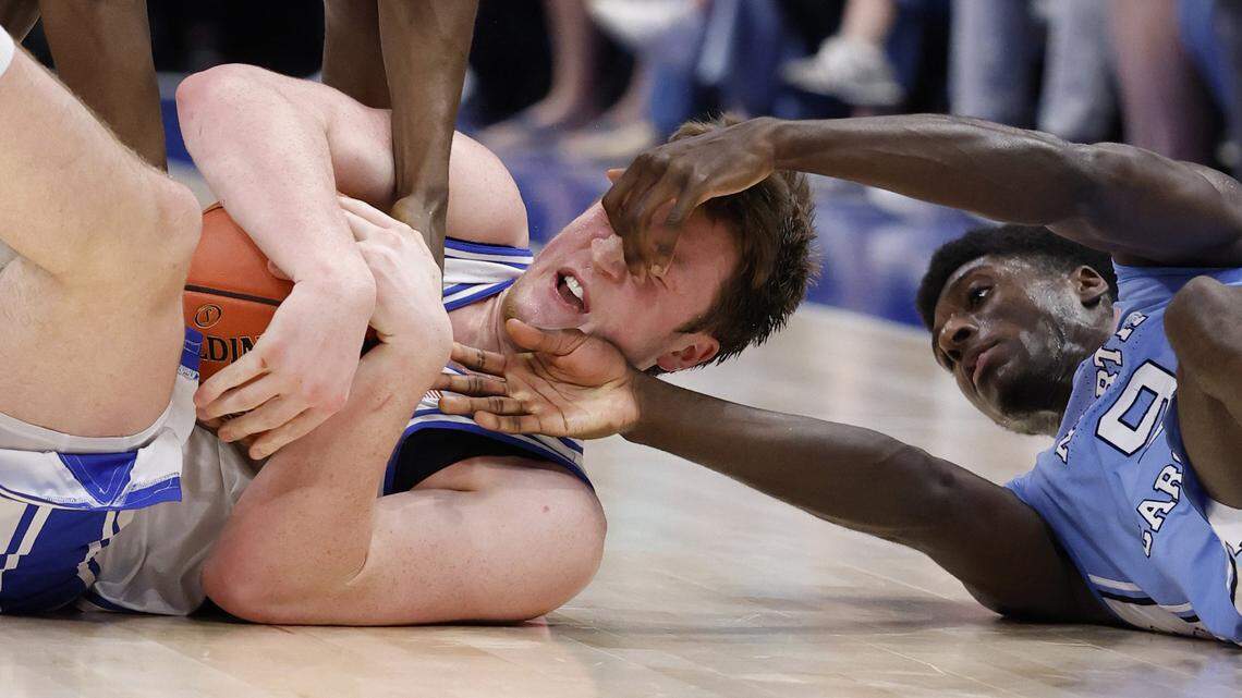 Duke’s Kon Knueppel (7) dives on a loose ball as North Carolina’s Drake Powell (9) tries to take it from him during the first half of Duke’s game against UNC in the semifinals of the 2025 ACC Men’s Basketball Tournament at the Spectrum Center in Charlotte, N.C., Friday, March 14, 2025.
