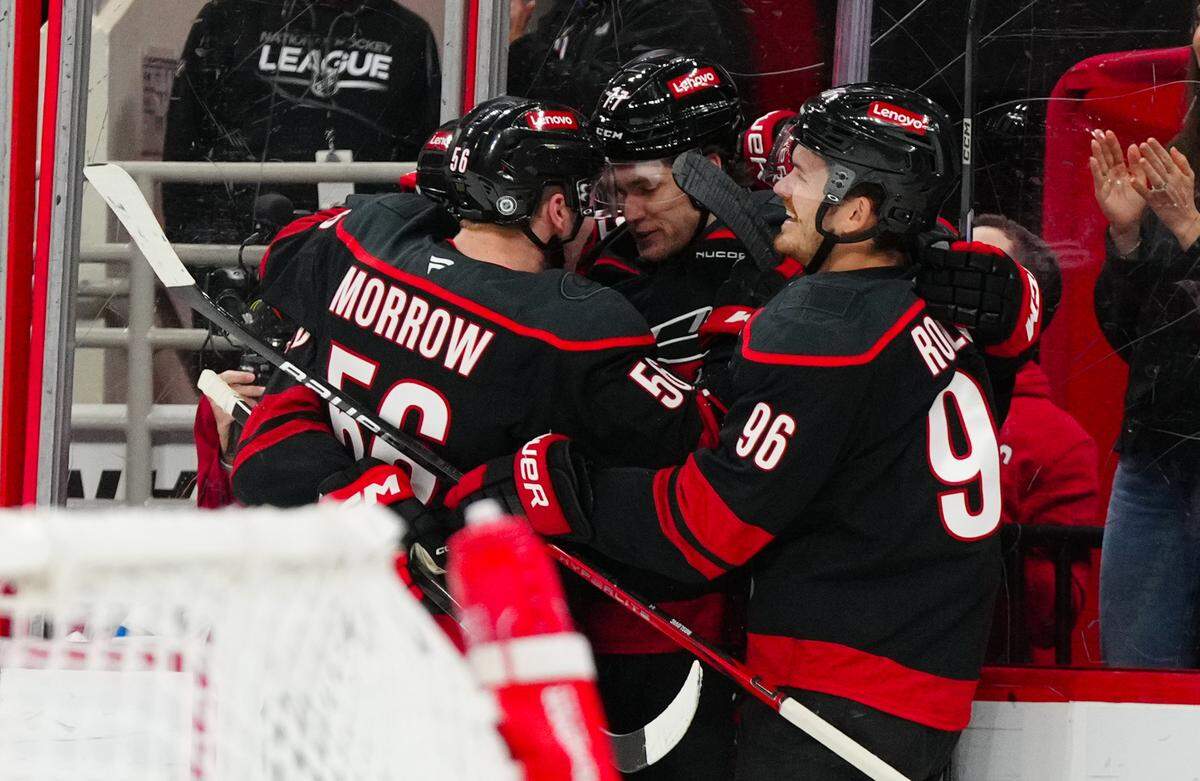 Mar 9, 2025; Raleigh, North Carolina, USA; Carolina Hurricanes center Mark Jankowski (77) is congratulated after his goal by center Jack Roslovic (96) and defenseman Scott Morrow (56) against the Winnipeg Jets during the first period at Lenovo Center. Mandatory Credit: James Guillory-Imagn Images