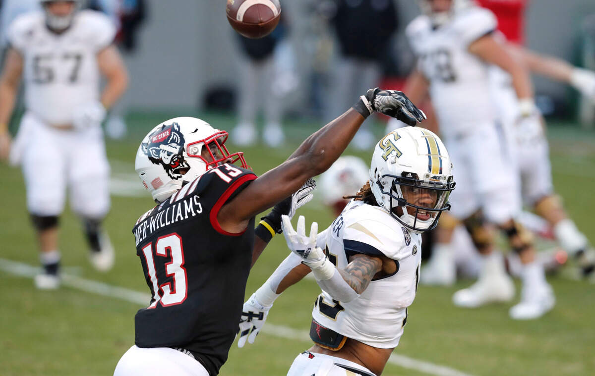 N.C. State defensive back Tyler Baker-Williams (13) breaks up a pass intended for Georgia Tech wide receiver Malachi Carter (15) during the first half of N.C. State’s game against Georgia Tech at Carter-Finley Stadium in Raleigh, N.C., Saturday, Dec. 5, 2020.