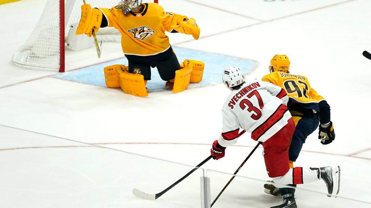 Carolina Hurricanes right wing Andrei Svechnikov (37) scores a goal against Nashville Predators goaltender Juuse Saros, top, in the third period of an NHL hockey game Saturday, Oct. 16, 2021, in Nashville, Tenn. The Hurricanes won 3-2. (AP Photo/Mark Humphrey)