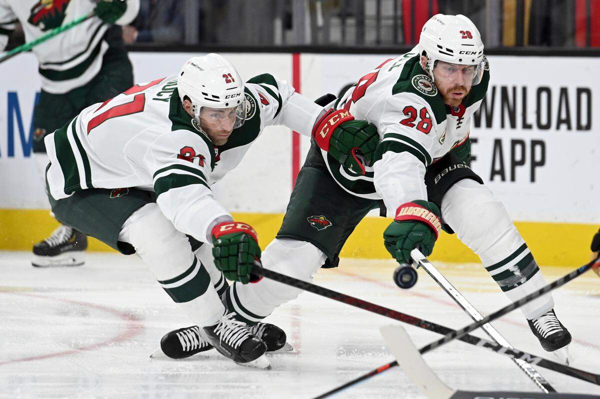 Minnesota Wild defenseman Carson Soucy (21) and defenseman Ian Cole (28) reach for the puck during the second period of Game 2 of the team’s first-round NHL hockey playoff series against the Vegas Golden Knights on Tuesday, May 18, 2021, in Las Vegas. (AP Photo/David Becker)