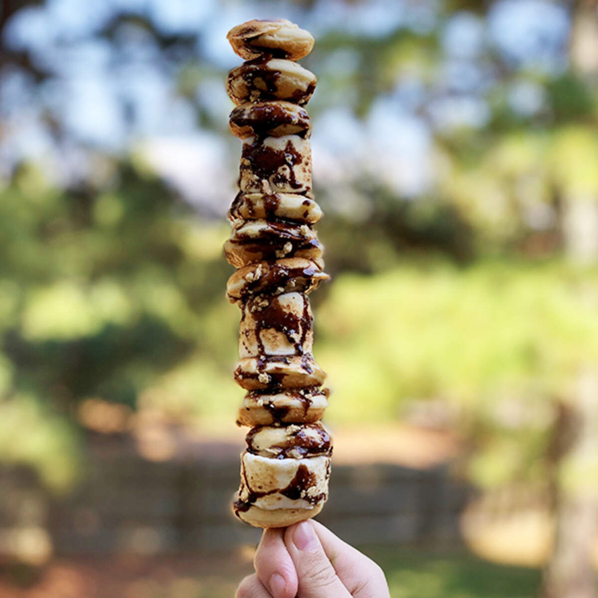 “Campfire on a Stick” from Hot Chix Hotcakes and Chicken food truck is a stack of mini pancakes and marshmallows covered in chocolate sauce and graham cracker crumbles.