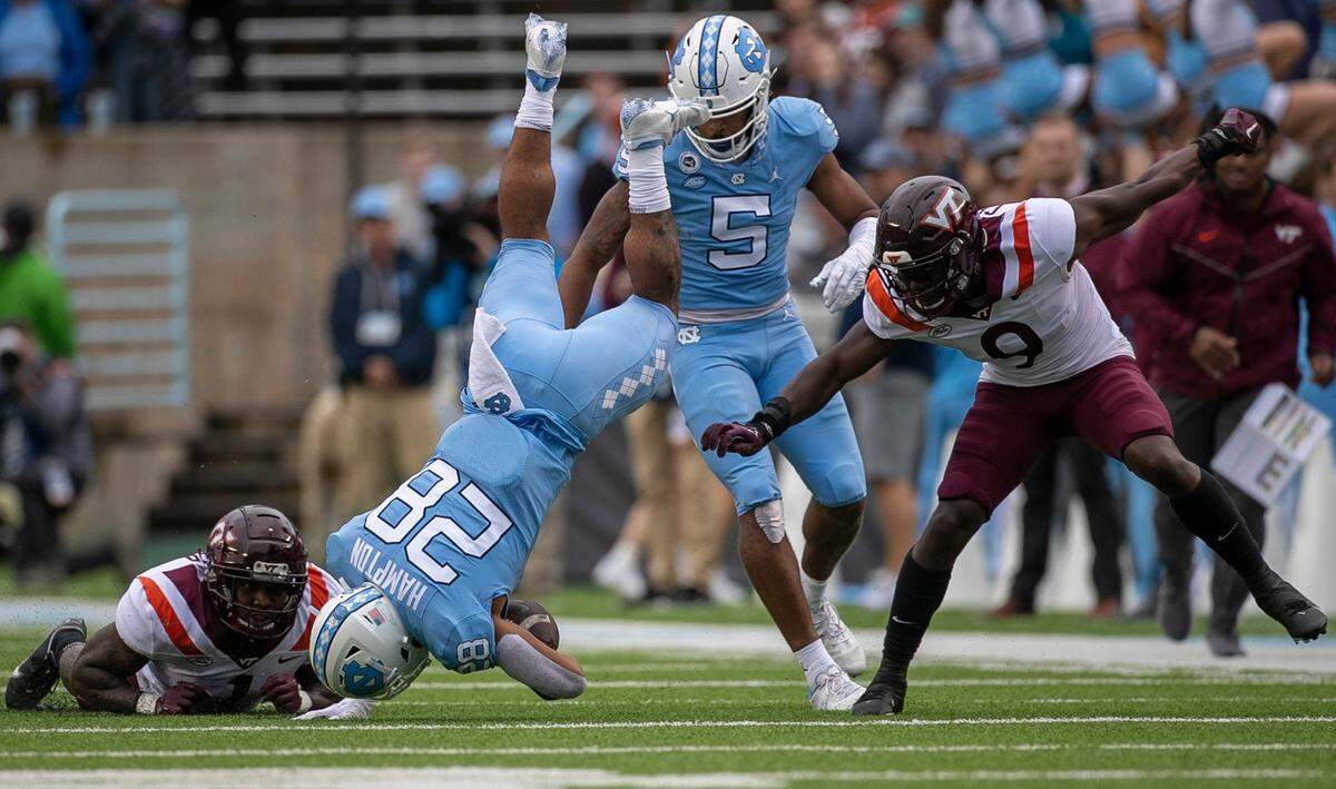 North Carolina’s Omarion Hampton (28) hurdles over Virginia Tech’s Chamarri Conner (1) for a nine yard gain in the first quarter on Saturday, October 1, 2022 at Kenan Stadium in Chapel Hill, N.C.