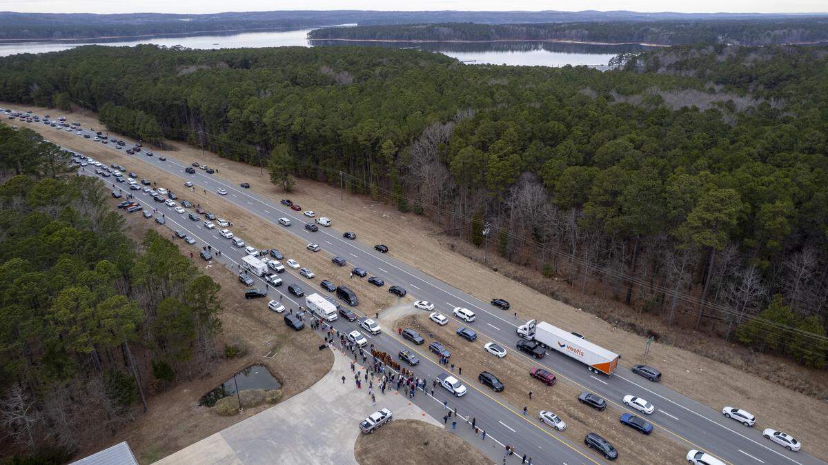 A procession of Buddhist monks walks along U.S. Highway 64 in Wilsonville on Friday, Jan. 23, 2026, as thousands of onlookers lined the highway to welcome them. The monks are making a 2,300-mile pilgrimage from Texas to Washington, D.C., as part of the “Walk for Peace,” an effort to promote peace, compassion and national unity.