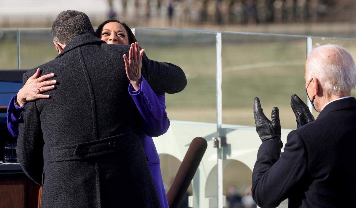 Vice President Kamala Harris hugs her husband Doug Emhoff after being sworn-in, as President Joe Biden applauds during the 59th Presidential Inauguration at the U.S. Capitol in Washington, Wednesday, Jan. 20, 2021.