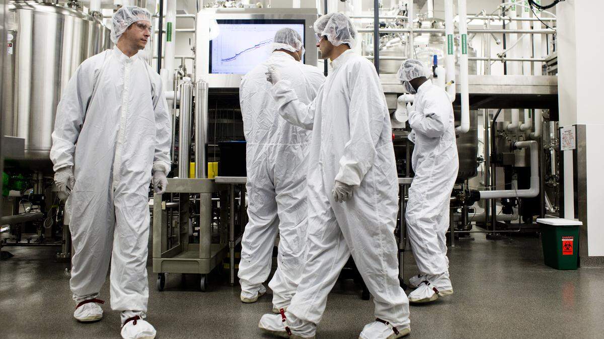 Biogen employees work inside a lab used to produce cell cultures in 2014 at the firm’s Research Triangle Park facilities.