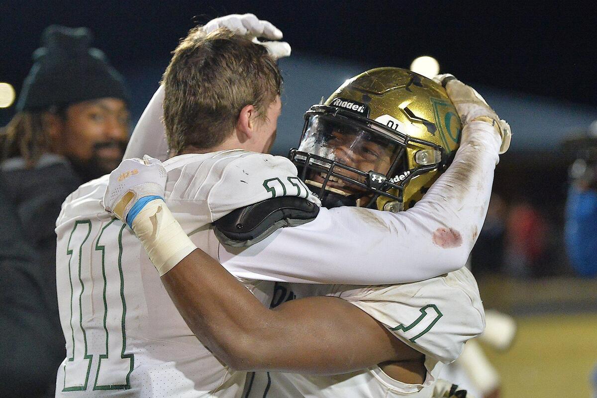 Cardinal Gibbons’ Jackson Fortney (11) and Will Mason (1) celebrate their team’s victory over Cleveland. The Cardinal Gibbons Crusaders and the Cleveland Rams met in the third round of the NCHSAA 4A football playoffs on November 19, 2021