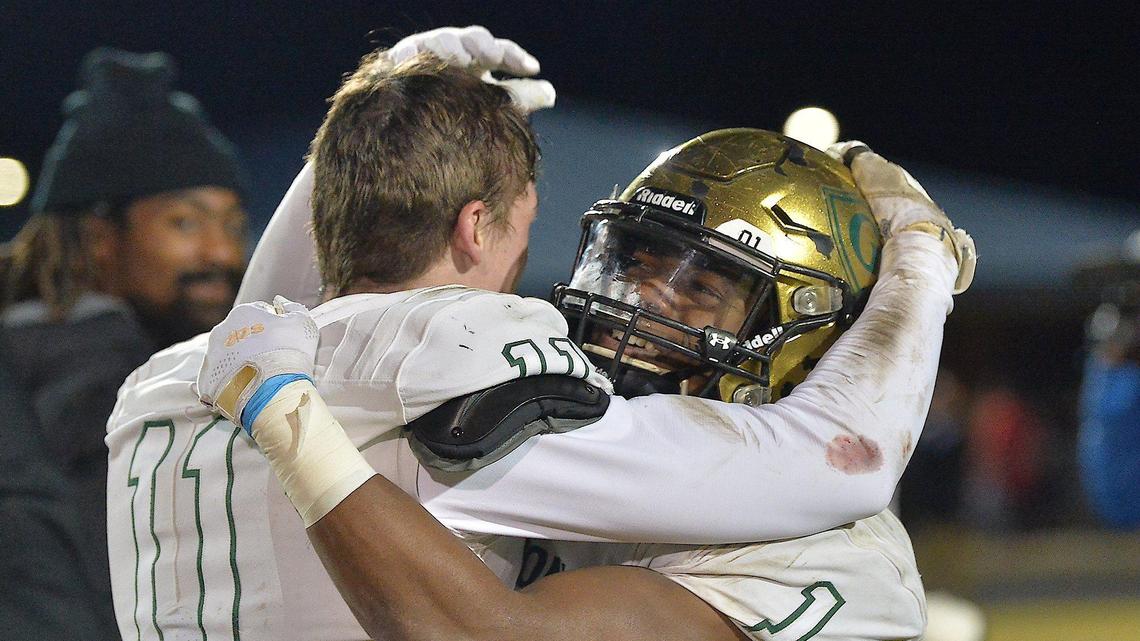 Cardinal Gibbons’ Jackson Fortney (11) and Will Mason (1) celebrate their team’s victory over Cleveland. The Cardinal Gibbons Crusaders and the Cleveland Rams met in the third round of the NCHSAA 4A football playoffs on November 19, 2021