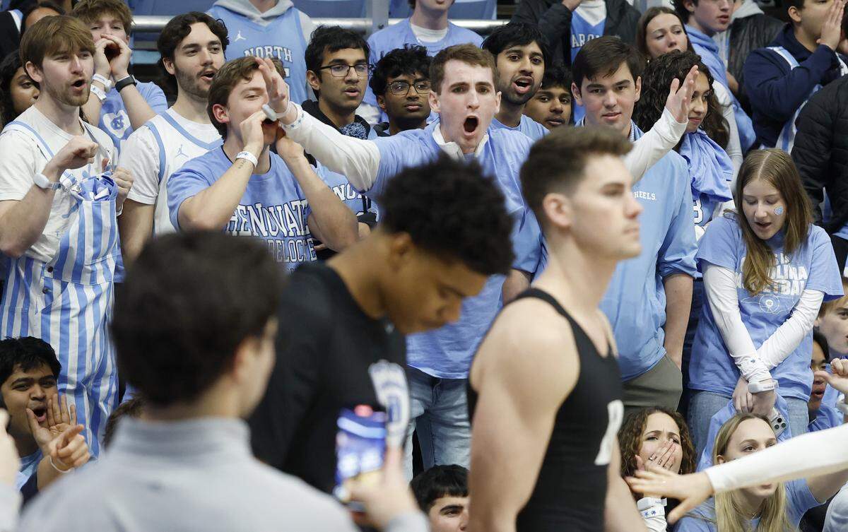 North Carolina fans jeer as Duke’s Cameron Sheffield and Jack Scott take to the floor to warmup before Duke’s game against UNC at the Dean E. Smith Center in Chapel Hill, N.C., Saturday, Feb. 7, 2026.