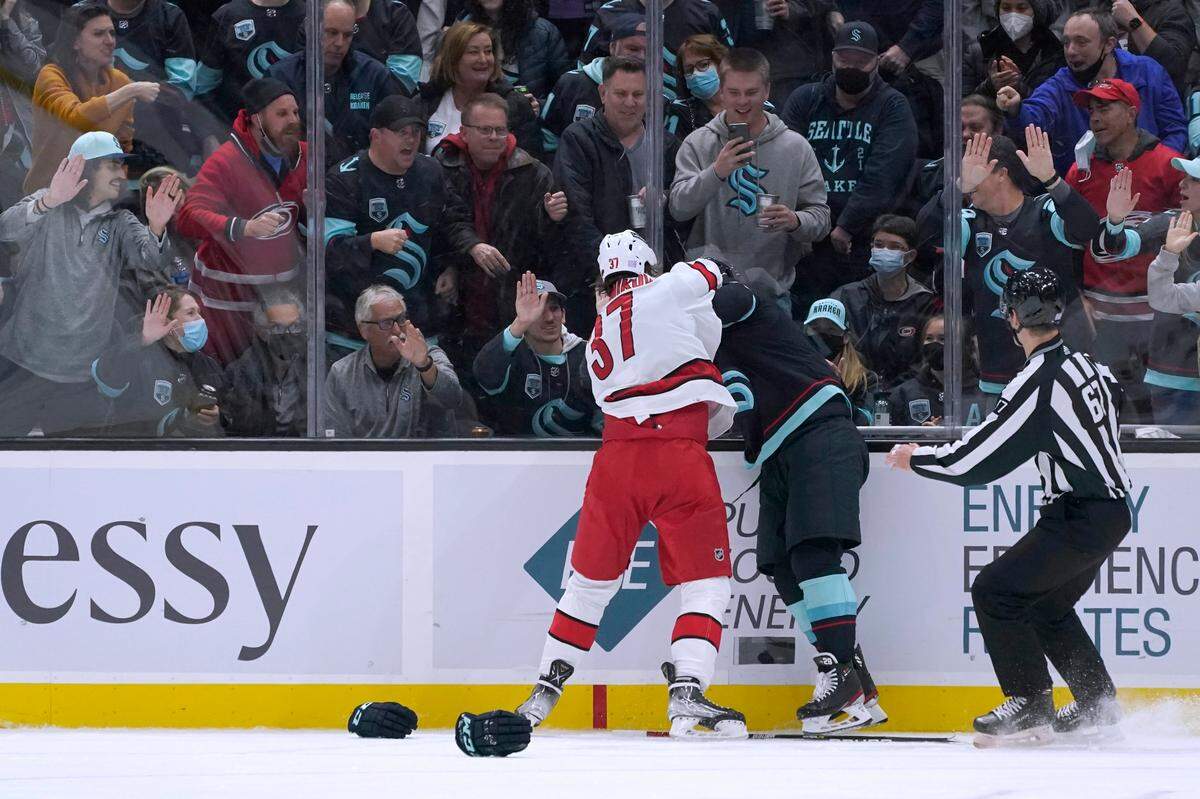 Fans cheer as Carolina Hurricanes right wing Andrei Svechnikov (37) fights with Seattle Kraken defenseman Vince Dunn (29) during the third period of an NHL hockey game Wednesday, Nov. 24, 2021, in Seattle. The Kraken won 2-1. (AP Photo/Ted S. Warren)