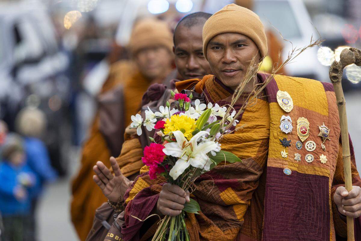 A procession of Buddhist monks walks along U.S. Highway 64 near Wilsonville on Friday, Jan. 23, 2026, as thousands of onlookers line the highway to welcome them. The monks are making a 2,300-mile pilgrimage from Texas to Washington, D.C., as part of the Walk for Peace, an effort to promote peace, compassion and national unity.