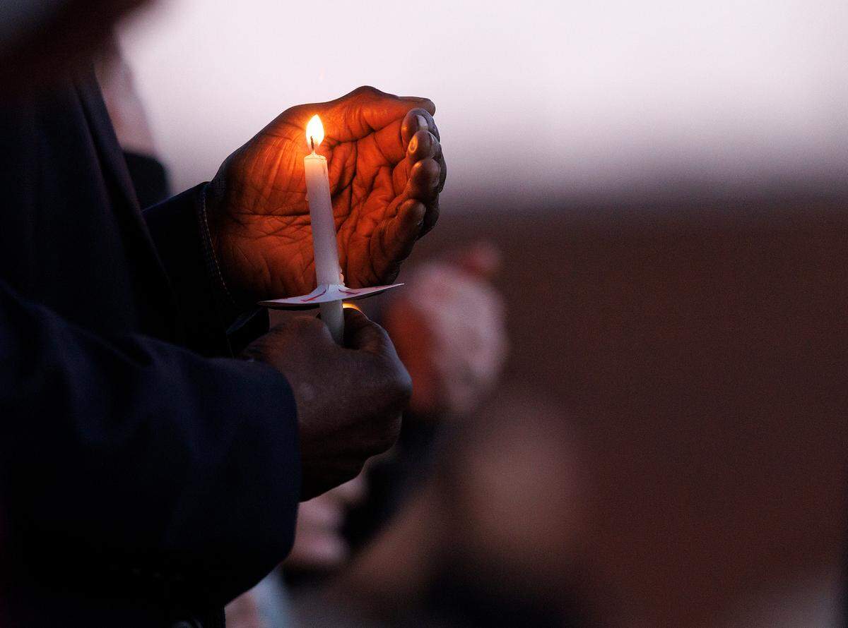 A person holds a candle during a vigil held outside the Apex Town Hall on Monday, Jan. 29, 2024, to honor Nancy Taylor and Gabrielle Raymond, who were shot and killed in an Apex neighborhood on Jan. 15.
