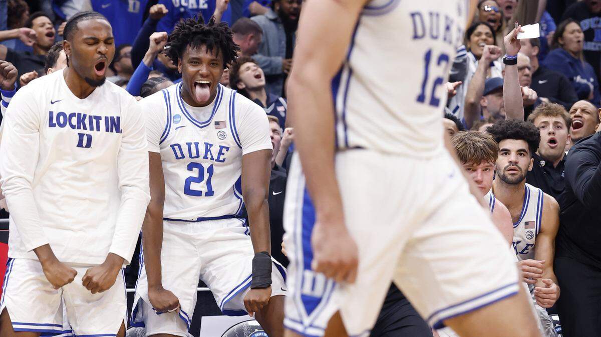 The Duke bench including Patrick Ngongba II (21) and Sebastian Wilkins celebrate after Cameron Boozer made the basket while being fouled during the second half of DukeÕs 80-75 victory over St. JohnÕs in the Sweet 16 of the NCAA MenÕs Basketball East Regional at Capital One Arena in Washington, D.C., Friday, March 27, 2026.