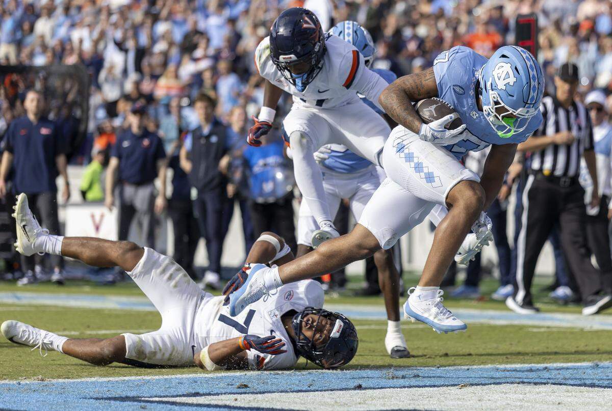 North Carolina running back Davion Gause (37) scores a touchdown in overtime on a nine-yard pass completion from quarterback Gio Lopez against Virginia safety Devin Neal (27) on Saturday, October 25, 2025 at Kenan Stadium in Chapel Hill, N.C.