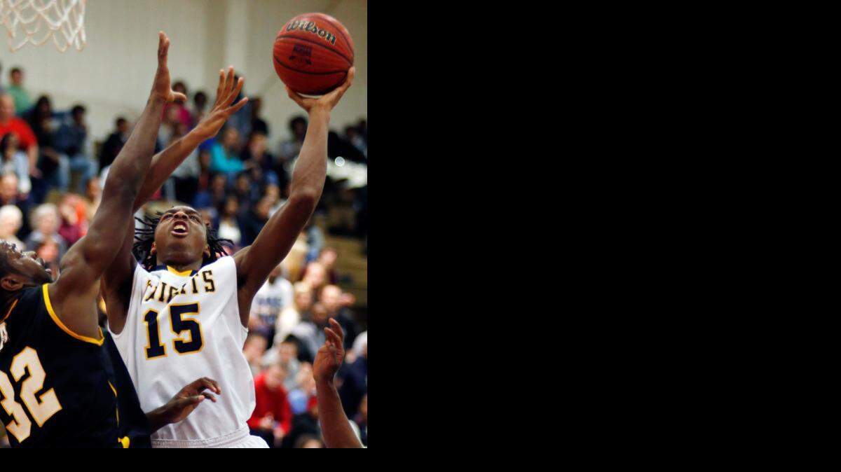 Northern's Kentrell Barkley (15) tries to get a shot over the defense of Apex's Ian Boyd (32) during Apex's third round playoff game at Northern Durham on Friday, February 28, 2014.
