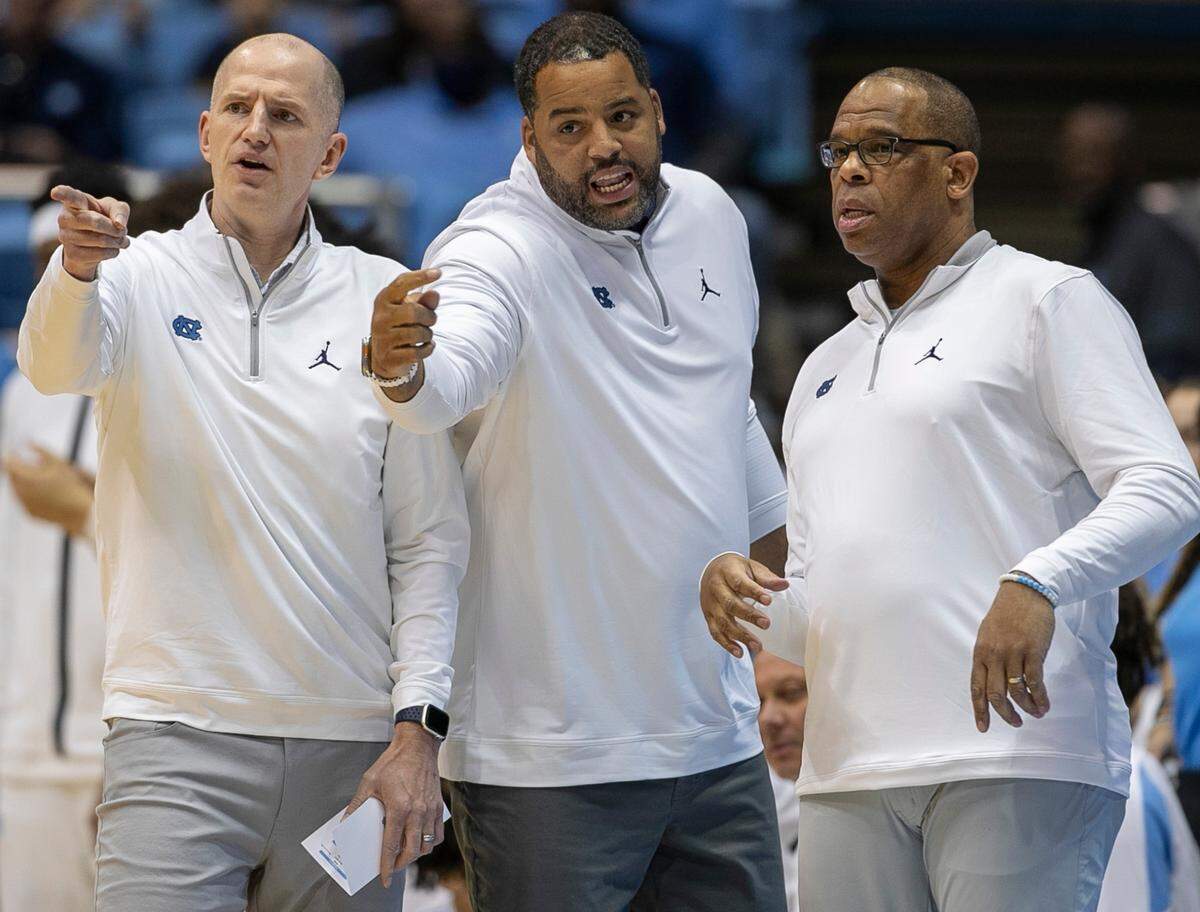North Carolina coach Hubert Davis confers with his assistant coaches Sean May and Brad Frederick in the first half against James Madison on Sunday, November 20, 2022 at the Smith Center in Chapel Hill, N.C.