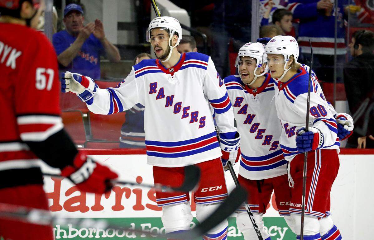 The Rangers' Ryan Sproul (25) celebrates his goal with John Gilmour (58) and Vladislav Namestnikov (90) during the second period.  The Canes' Trevor van Riemsdyk (57) looks on. The Rangers beat the Canes 2-1.  The loss denies the Canes any chance of making the playoffs.