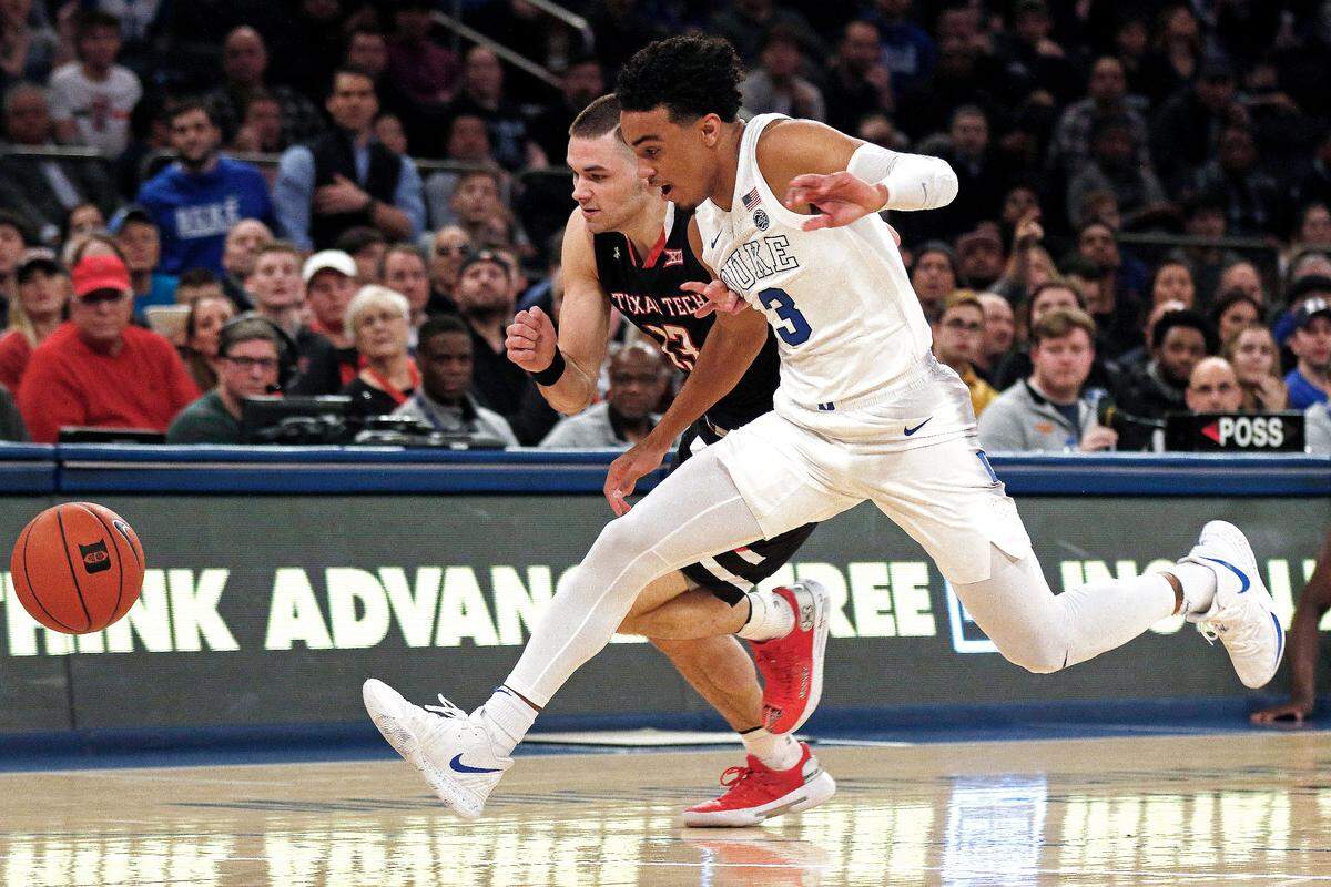 Duke guard Tre Jones, front, chases down a loose ball against Texas Tech guard Matt Mooney (13) during the first half Thursday, Dec. 20, 2018, in New York. Duke won 69-58.
