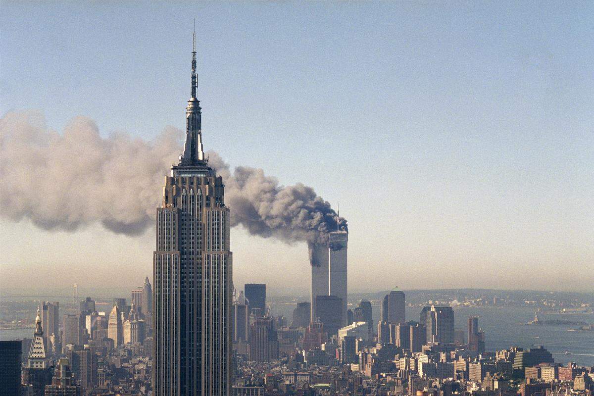 In this Sept. 11, 2001, file photo, the twin towers of the World Trade Center burn behind the Empire State Building in New York.