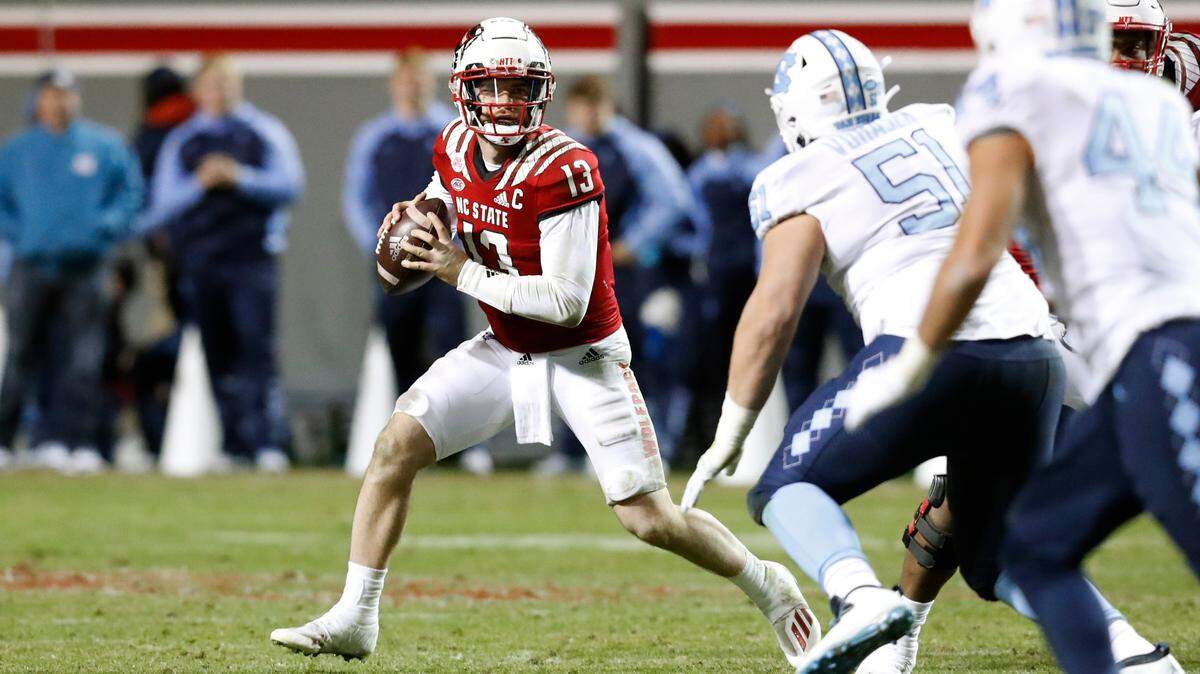 N.C. State quarterback Devin Leary (13) looks for a receiver downfield during the second half of N.C. State’s 34-30 victory over UNC at Carter-Finley Stadium in Raleigh, N.C., Friday, November 26, 2021.
