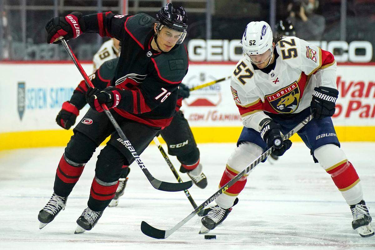 Carolina Hurricanes defenseman Brady Skjei (76) and Florida Panthers defenseman MacKenzie Weegar (52) skate for the puck during the second period of an NHL hockey game in Raleigh, N.C., Thursday, April 8, 2021. (AP Photo/Gerry Broome)