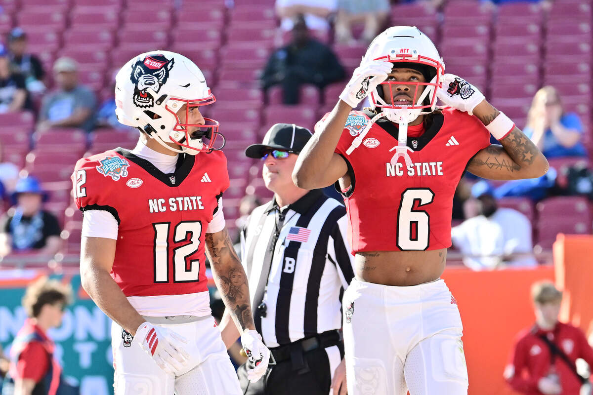 N.C. State’s Wesley Grimes, right, celebrates with teammate Teddy Hoffman after scoring a touchdown in the first half against the Memphis Tigers during the 2025 Union Home Mortgage Gasparilla Bowl at Raymond James Stadium on Dec. 19, 2025, in Tampa, Florida.
