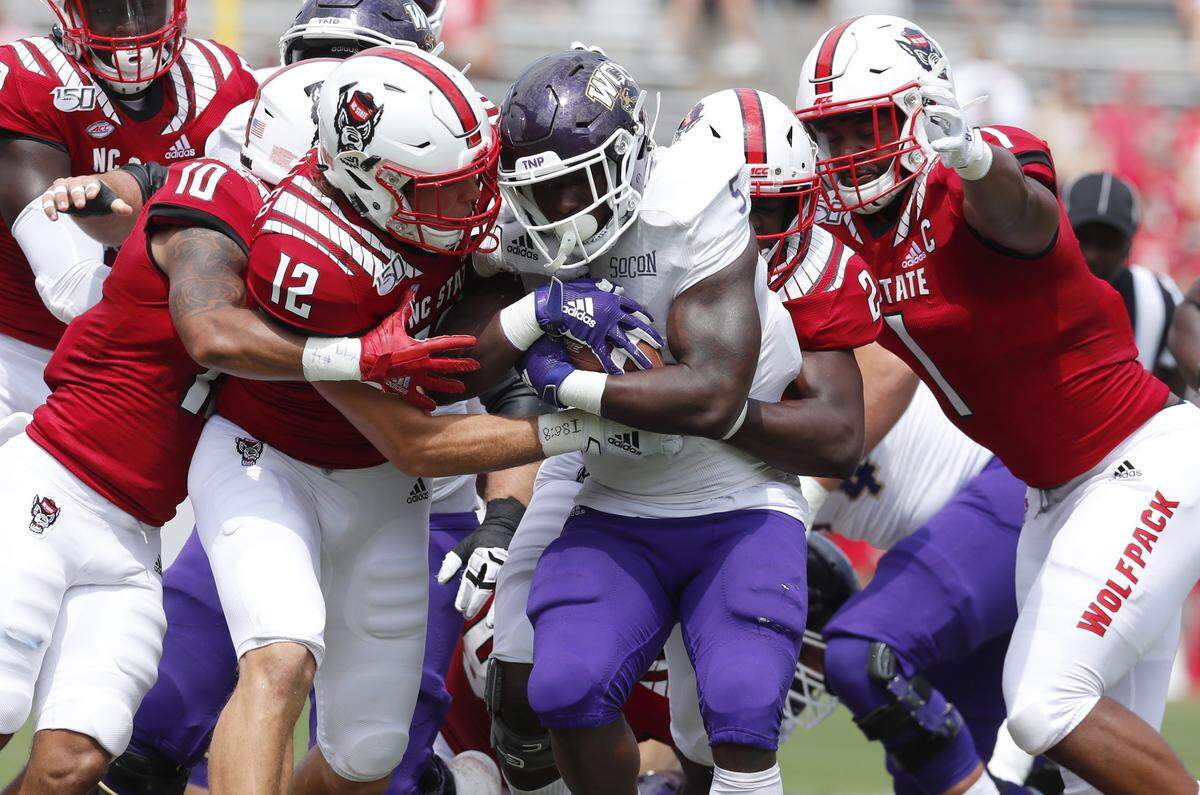 N.C. State’s Tanner Ingle (10), Brock Miller (12), Louis Acceus (2) and James Smith-Williams (1) stop Western Carolina running back Connell Young (5) during the first half of N.C. State’s game against Western Carolina at Carter-Finley Stadium in Raleigh, N.C., Saturday, Sept. 7, 2019.