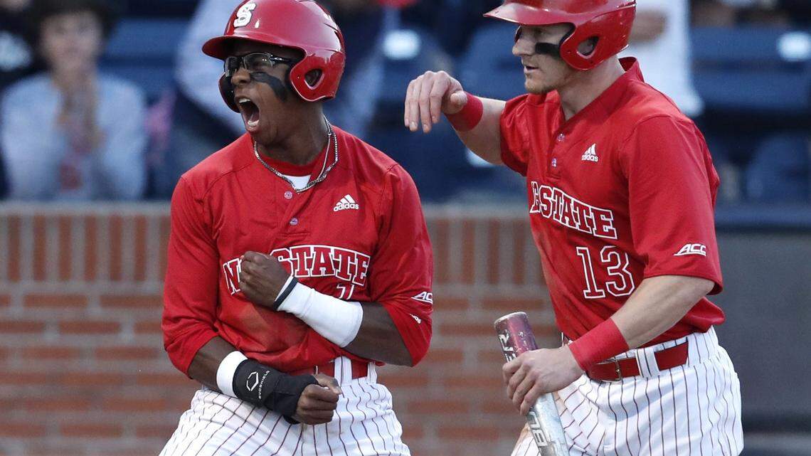 N.C. State's Terrell Tatum (1) and Brock Deatherage (13) celebrate after scoring in the fourth inning during N.C. State's 8-3 victory over UNC at the Durham Bulls Athletic Park in Durham, N.C., Tuesday, April 17, 2018.