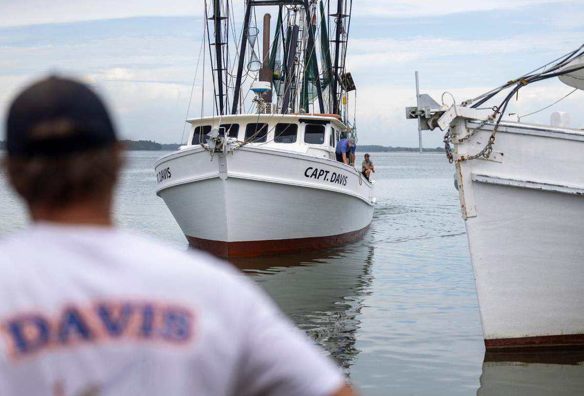 Jody Davis waits at the dock, outside the fish house he co-owns, to unload brown shrimp caught by a crew captained by his older brother Billy Davis.