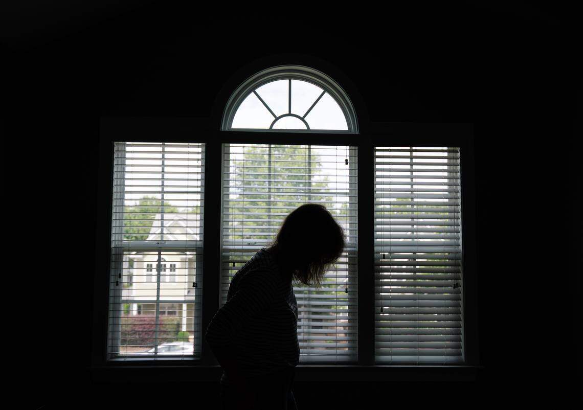Jill Rohner is silhouetted against a bedroom window while moving out of her former home on Wednesday, May 28, 2025, in Raleigh, N.C. 