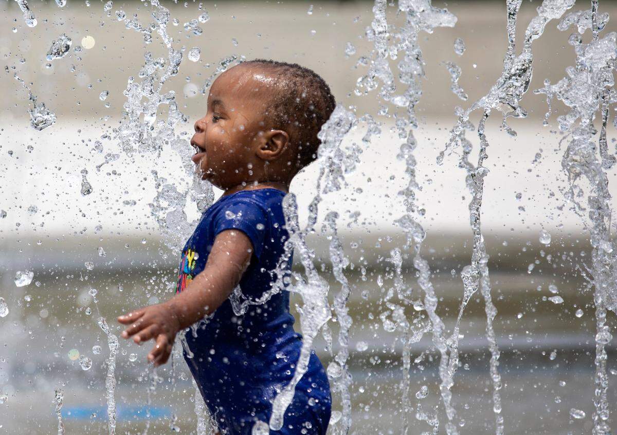 Nymir Pratt, 1, delights in walking through a splash pad at John Chavis Memorial Park on Tuesday, June 14, 2022, in Raleigh, N.C. Temperatures have been in the 90s many days this month in Charlotte and Raleigh.