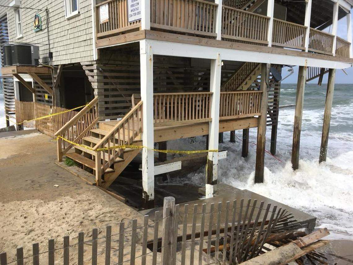 Yellow caution tape wrapped around a Rodanthe house that is falling into the ocean.