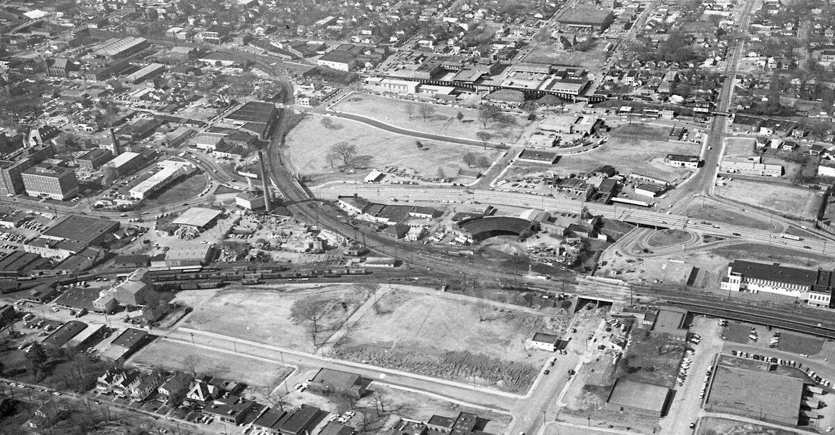 Aerial view looking west of the area of Raleigh, NC known as “Smokey Hollow” in 1960. Peace Street runs from top to bottom at the right side of the photo and downtown Raleigh is at far left.