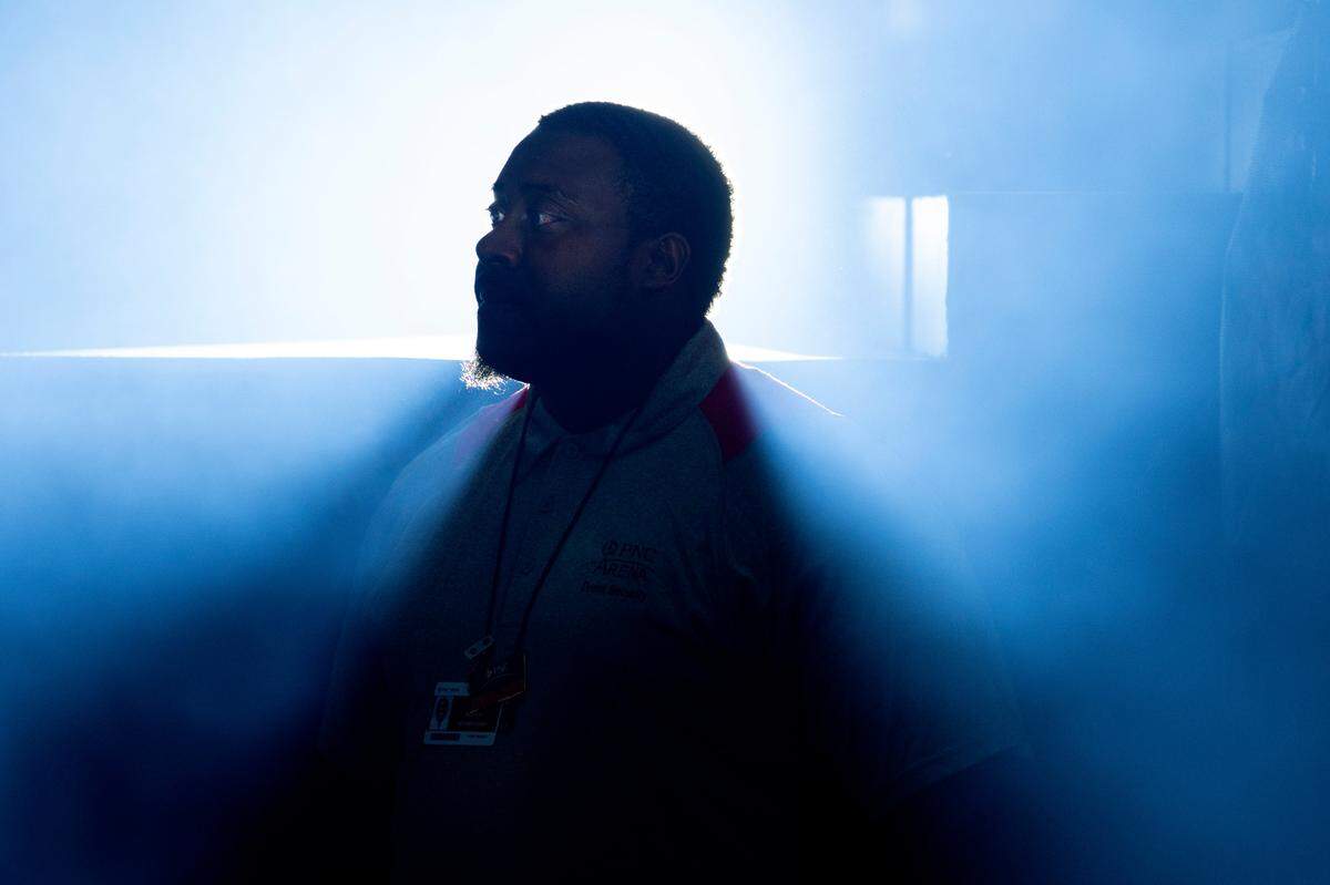 A blue haze surrounds a security guard in the stage pit at the Lil Baby concert at PNC Arena.
