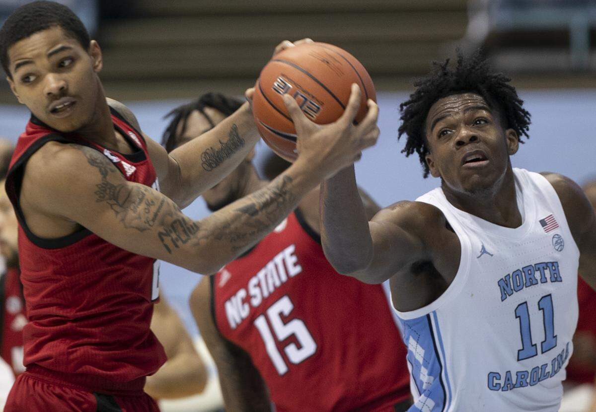 N.C. State’s Shakeel Moore (2) secures a defensive rebound over North Carolina’s DayÕRon Sharpe (11) in the first half on Saturday, January 23, 2021 at the Smith Center in Chapel Hill, NC.