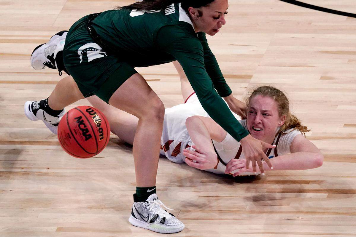 Iowa State guard Emily Ryan, bottom, passes past Michigan State guard Alyza Winston (3) during the first half of a college basketball game in the first round of the women’s NCAA tournament at the Alamodome in San Antonio, Monday, March 22, 2021.