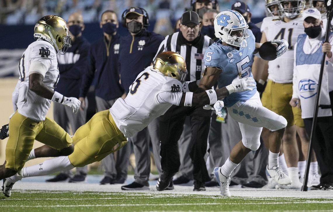 North Carolina’s Dazz Newsome (5) is forced out of bounds by Notre Dame’s Jeremiah Owusu-Koramoah (6) after a pass reception from quarterback Sam Howell for a gain five-yard in the fourth quarter on Friday, November 27, 2020 at Kenan Stadium in Chapel Hill, N.C.