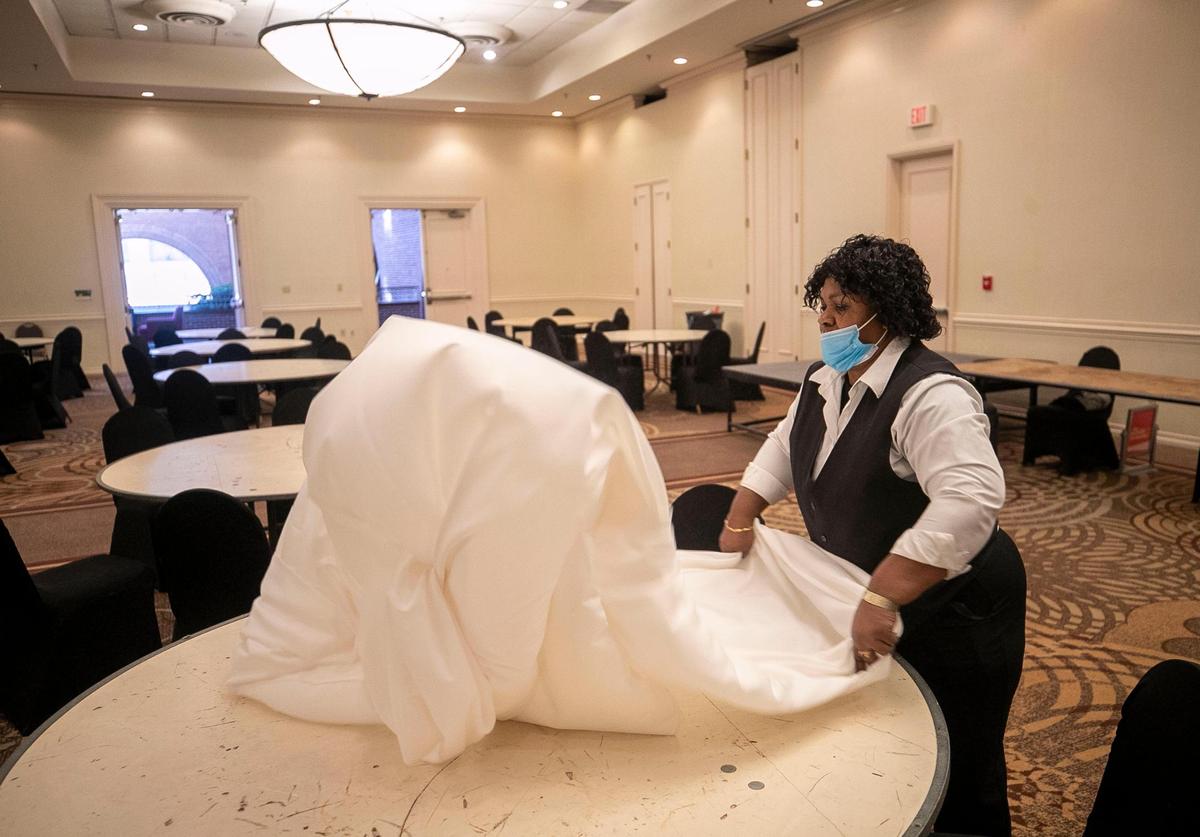 Pauline Nwufo sets up a banquet table at the Sheraton Hotel on Tuesday, October 26, 2021 in Raleigh, N.C. She has worked for the Sheraton for 16 years.