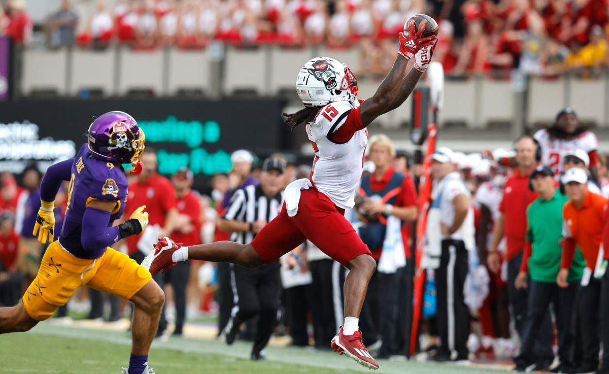 N.C. State wide receiver Keyon Lesane (15) makes the reception as East Carolina safety Teagan Wilk (9) trails during the second half of N.C. States 21-20 victory over ECU at Dowdy-Ficklen Stadium in Greenville, N.C., Saturday, Sept. 3, 2022.