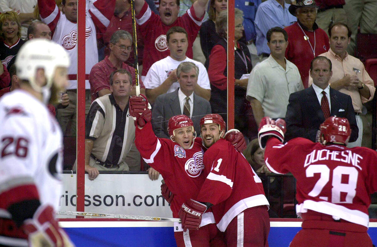 CANESWINGS28.SP.060802.STF--RALEIGH,NC--06/08/02--Before a stunned Hurricanes crowd, the Detroit Red Wings Igor Larionov, left, celebrates his 3 OT game winner with teammates Mathieu Dandenault and #28 Steve Duchesne. in Game 3 at the ESA. NEWS AND OBSERVER STAFF PHOTO:ROBERT WILLETT